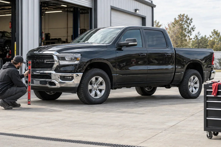 RAM 1500 parked on level pavement while a technician evaluates the front-to-rear stance after a mild leveling kit installation.